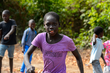 SOGA, GUINEA BISSAU - MAY 5, 2017: Unidentified local boy in violet shirt walks in a village of the Soga island. People in G.-Bissau still suffer of povertyのeditorial素材