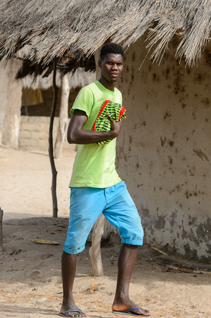 ORANGO ISLAND, GUINEA BISSAU - MAY 3, 2017: Unidentified local boy walks along the street in the Etigoca village. People in G.-Bissau suffer of poverty due to the bad economyのeditorial素材