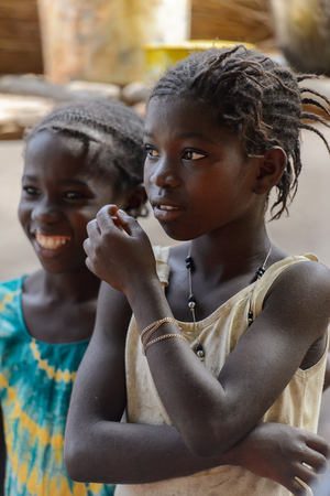 CANHABAQUE, GUINEA BISSAU - MAY 4, 2017: Unidentified local girls stand in a village of the Canhabaque island. People in G.-Bissau still suffer of povertyのeditorial素材
