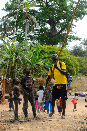 SOGA, GUINEA BISSAU - MAY 5, 2017: Unidentified local man with backpack holds a wooden stick in a village of the Soga island. People in G.-Bissau still suffer of povertyのeditorial素材