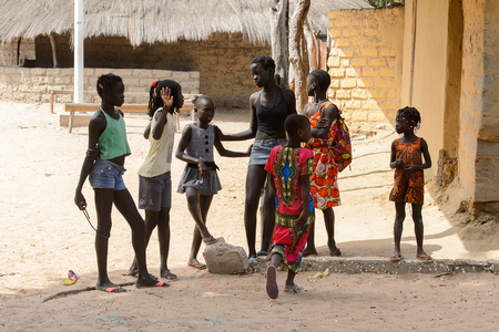 ORANGO ISLAND, GUINEA BISSAU - MAY 3, 2017: Unidentified local children talk about something in the Etigoca village. People in G.-Bissau suffer of poverty due to the bad economyのeditorial素材