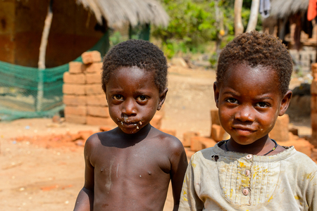 SOGA, GUINEA BISSAU - MAY 5, 2017: Unidentified local children walk along the street in a village of the Soga island. People in G.-Bissau still suffer of povertyのeditorial素材