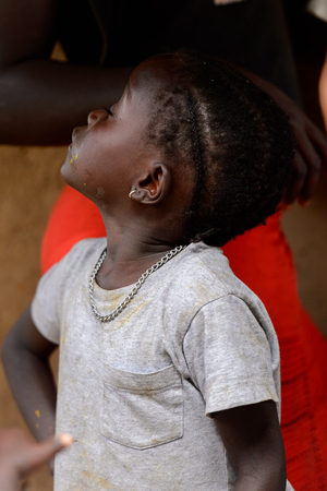 ORANGO ISLAND, GUINEA BISSAU - MAY 3, 2017: Unidentified local little girl looks up in the Etigoca village. People in G.-Bissau suffer of poverty due to the bad economyのeditorial素材