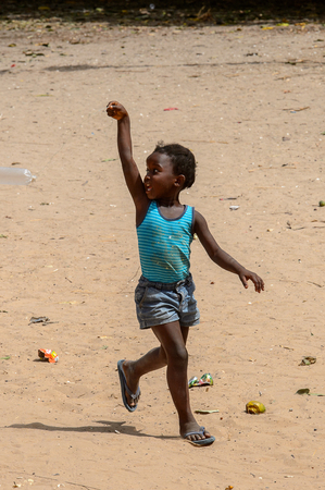 ORANGO ISLAND, GUINEA BISSAU - MAY 3, 2017: Unidentified local little girl plays in the yard in the Etigoca village. People in G.-Bissau suffer of poverty due to the bad economyのeditorial素材