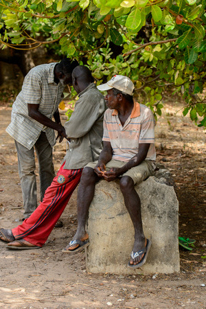 SOGA, GUINEA BISSAU - MAY 5, 2017: Unidentified local man sits on the stone in a village of the Soga island. People in G.-Bissau still suffer of povertyのeditorial素材