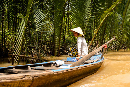 SONG NUOC MIEN TAY, VIETNAM - OCT 5, 2014: Unidentified Vietnamese woman sails a boat over the Mekong river. Mekong is the 12th longest river in the worldのeditorial素材