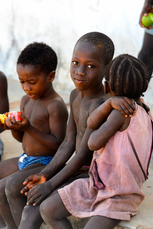 BUBAQUE, GUINEA BISSAU - MAY 5, 2017: Unidentified local children sit at the causeway in a village of the Bubaque island. People in G.-Bissau still suffer of povertyのeditorial素材