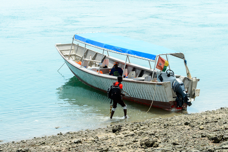 BUBAQUE, GUINEA BISSAU - MAY 5, 2017: Unidentified local man walks near the boat in a village of the Bubaque island. People in G.-Bissau still suffer of povertyのeditorial素材