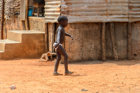 BUBAQUE, GUINEA BISSAU - MAY 5, 2017: Unidentified local little boy walks along the street in a village of the Bubaque island. People in G.-Bissau still suffer of povertyのeditorial素材