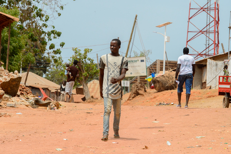 BUBAQUE, GUINEA BISSAU - MAY 5, 2017: Unidentified local man walks along the street in a village of the Bubaque island. People in G.-Bissau still suffer of povertyのeditorial素材