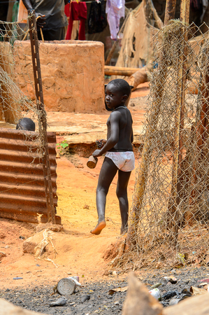 BUBAQUE, GUINEA BISSAU - MAY 5, 2017: Unidentified local little boy walks along the street in a village of the Bubaque island. People in G.-Bissau still suffer of povertyのeditorial素材