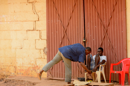 BUBAQUE, GUINEA BISSAU - MAY 5, 2017: Unidentified local man in a shirt bends down in a village of the Bubaque island. People in G.-Bissau still suffer of povertyのeditorial素材