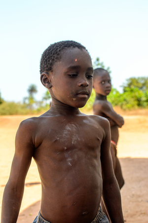 BUBAQUE, GUINEA BISSAU - MAY 5, 2017: Unidentified local little boy stands on the street in a village of the Bubaque island. People in G.-Bissau still suffer of povertyのeditorial素材