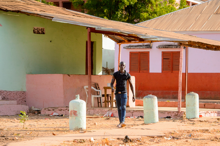 BOLAMA ISLAND, GUINEA BISSAU - MAY 6, 2017: Unidentified local man walks along the street in the ghost town of Bolama, the former capital of Portuguese Guineaのeditorial素材