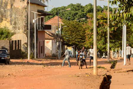 BOLAMA ISLAND, GUINEA BISSAU - MAY 6, 2017: Unidentified local man rides a motorcycle in the ghost town of Bolama, the former capital of Portuguese Guineaのeditorial素材
