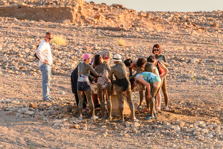 DEAD SEA RESORT, JORDAN - APR 30, 2014: Unidentified Chinese tourists in the mud of the Dead Sea. Dead Sea mud posesses the medical qualities and helps to the people with skin problemsのeditorial素材