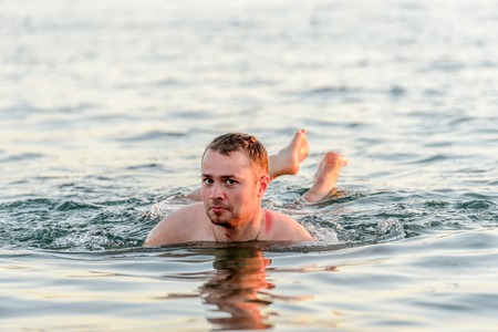 DEAD SEA RESORT, JORDAN - APR 30, 2014: Unidentified man swims in the Dead Sea water. Dead Sea water is used for medical purposes for the people with skin problemsのeditorial素材