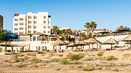 DEAD SEA RESORT, JORDAN - APR 30, 2014: Beach at the Dead Sea coast in Jordan. Dead Sea water is used for medical purposes for the people with skin problemsのeditorial素材