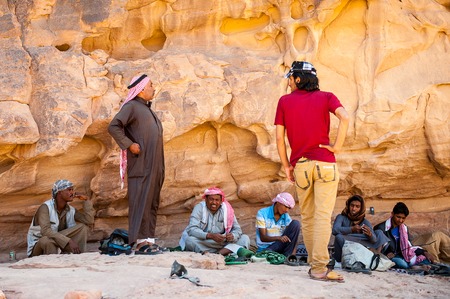 WADI RUM, JORDAN - APR 30, 2014: Unidentified local bedouins near the rock in the desert of Wadi Rum. Bedouins are a part of a desert-dwelling Arabian ethnic groupのeditorial素材