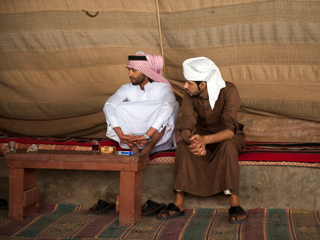 WADI RUM, JORDAN - APR 30, 2014: Unidentified bedouins drink tea made by the traditional bedouin way. Bedouins are a part of a desert-dwelling Arabian ethnic groupのeditorial素材