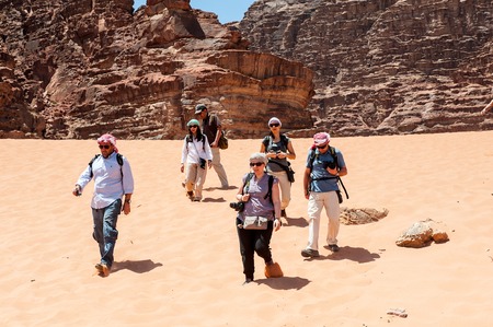 WADI RUM, JORDAN - APR 30, 2014: Unidentified tourists walk over the Wadi Rum valley. Wadi Rum...