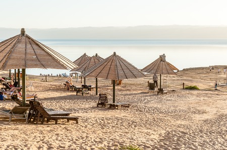 DEAD SEA RESORT, JORDAN - APR 30, 2014: Beach at the Dead Sea coast in Jordan. Dead Sea water is used for medical purposes for the people with skin problemsのeditorial素材