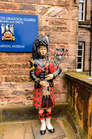 EDINBURGH, SCOTLAND - JULY 17, 2016: Figure playing a bagpipes at the  Edinburgh Castle. The Castle was involved in many historical conflicts since 14th centuryのeditorial素材