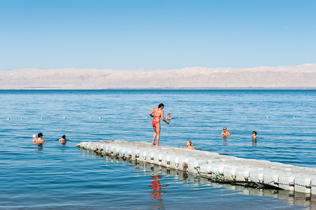 DEAD SEA RESORT, JORDAN - MAY 1, 2014: Unidentified people at the Beach at the Dead Sea coast in Jordan. Dead Sea water is used for medical purposes for the people with skin problemsのeditorial素材