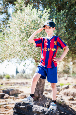 GADARA, JORDAN - MAY 2, 2014: Unidentified boy in a Barcelona shirt in the ancient town of Gadara, Jordan. By the third century BC the Gadara town was of some cultural importance.のeditorial素材