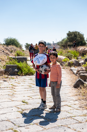 GADARA, JORDAN - MAY 2, 2014: Unidentified two boys in the ancient town of Gadara, Jordan. By the third century BC the Gadara town was of some cultural importance.のeditorial素材