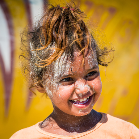 SOCOTRA, YEMEN - JAN 12, 2014: Unidentified Yemeni little girl with sand on her face plays on the beach of the Island of Socotra. Children in Socotra live in poverty and grow without educationのeditorial素材