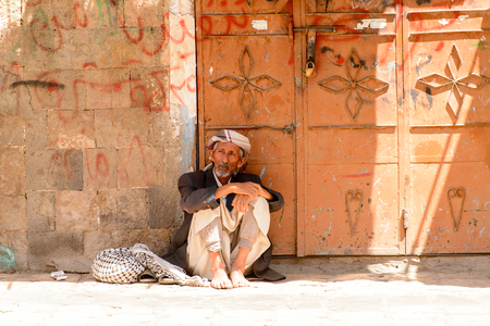 SANA'A, YEMEN - JAN 11, 2014: Unidentified Yemeni old man sits in the street. People of Yemen suffer of poverty due to the unstable political and poor economical situationのeditorial素材