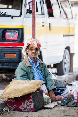 SANA'A, YEMEN - JAN 11, 2014: Unidentified Yemeni man sits on the ground. People of Yemen suffer of poverty due to the unstable political and poor economical situationのeditorial素材