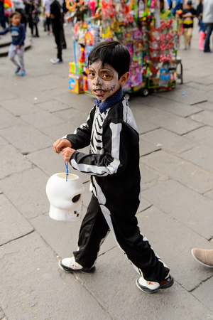 PUEBLA, MEXICO - OCT 30, 2016: Unidentified girl dressed as a skeleton for the Day of the Dead (Dia de los Muertos), national Mexican holiday, UNESCO Intangible Cultural Heritage of Humanityのeditorial素材