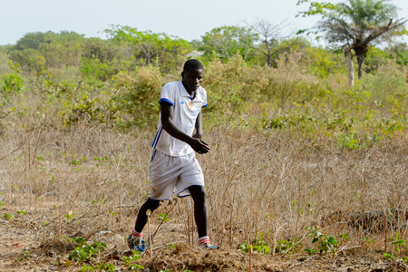 ORANGO ISLAND, GUINEA BISSAU - MAY 3, 2017: Unidentified local football player walks along the field after a physical culture lesson on the Orange islandのeditorial素材
