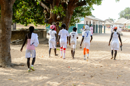 ORANGO ISLAND, GUINEA BISSAU - MAY 3, 2017: Unidentified local girls in football uniform walk from behind after a physical culture lesson on the Orange islandのeditorial素材