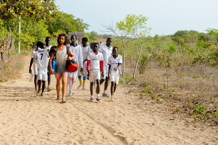 ORANGO ISLAND, GUINEA BISSAU - MAY 3, 2017: Unidentified local coach and his team come back after a physical culture lesson on the Orange islandのeditorial素材