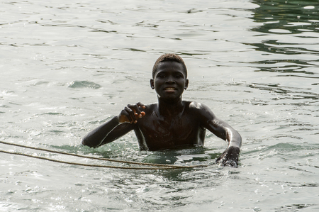RUBANE, GUINEA BISSAU - MAY 4, 2017: Unidentified local boy swims in water during a high tideのeditorial素材