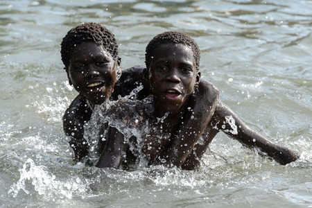 RUBANE, GUINEA BISSAU - MAY 4, 2017: Unidentified local boys swim in water during a high tideのeditorial素材