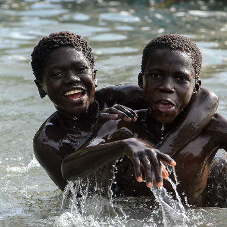 RUBANE, GUINEA BISSAU - MAY 4, 2017: Unidentified local boys swim in water during a high tideのeditorial素材