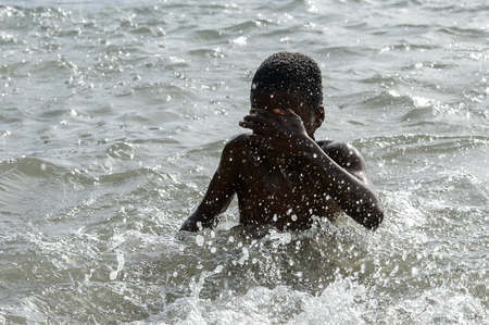 RUBANE, GUINEA BISSAU - MAY 4, 2017: Unidentified local boy swims in water during a high tideのeditorial素材