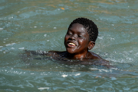 RUBANE, GUINEA BISSAU - MAY 4, 2017: Unidentified local boy swims in water during a high tideのeditorial素材