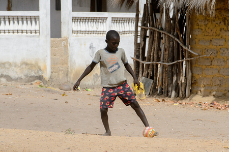 ORANGO ISLAND, GUINEA BISSAU - MAY 3, 2017: Unidentified local boy plays football on the Orange islandのeditorial素材