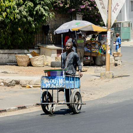 DAKAR, SENEGAL - APR 23, 2017: Unidentified Senegalese man pulls a cart along the road in Dakar, the capital and main city of Senegalのeditorial素材