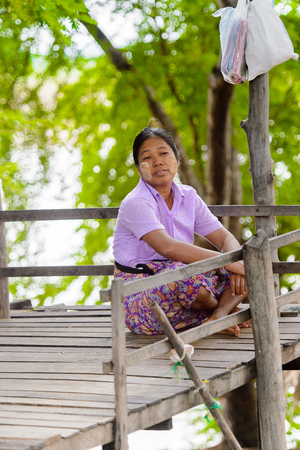INWA, MYANMAR - AUG 25, 2016: Unidentified Burmese woman sits. 68 per cent of  Myanma people belong to Bamar ethnic groupのeditorial素材
