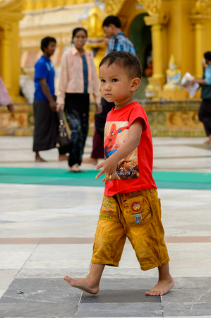 YANGON, MYANMAR - AUG 24, 2016: Unidentified Burmese little boy in a local temple. 68 per cent of Myanma people belong to Bamar ethnic groupのeditorial素材