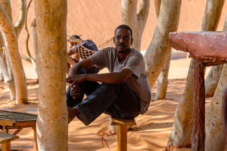 LAMPOUL DESERT, SENEGAL - APR 23, 2017: Unidentified Senegalese man sits on the bench in a Lampoul Desert, beautiful landscape placeのeditorial素材