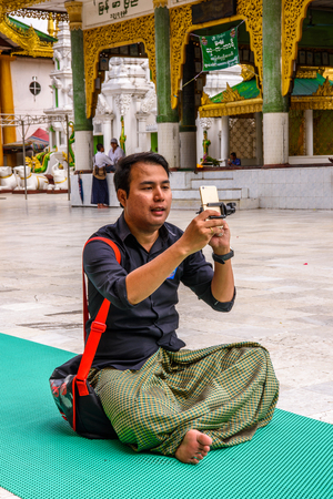 YANGON, MYANMAR - AUG 24, 2016: Unidentified Burmese man in a local temple. 68 per cent of Myanma people belong to Bamar ethnic groupのeditorial素材