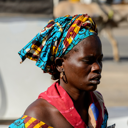 SAINT LOUIS, SENEGAL - APR 24, 2017: Unidentified Senegalese woman in colored headscarf looks ahead in Saint Louis, one of the major cities in Senegalのeditorial素材