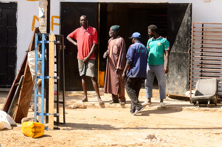 ROAD TO LAMPOUL, SENEGAL - APR 23, 2017: Unidentified Senegalese four men stand beside the road....